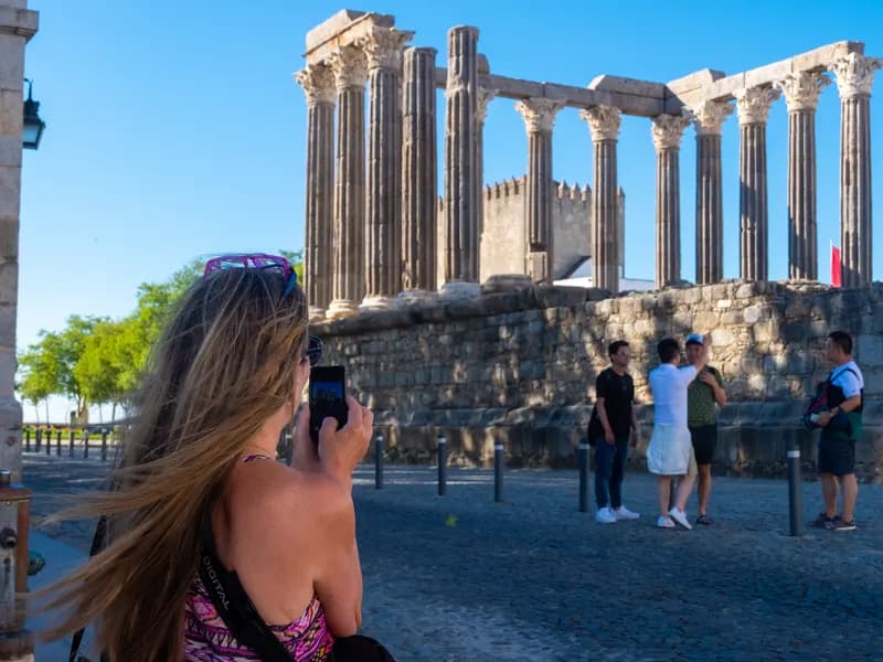 Toeristen fotograferen de Romeinse Tempel van Diana in Évora, Portugal