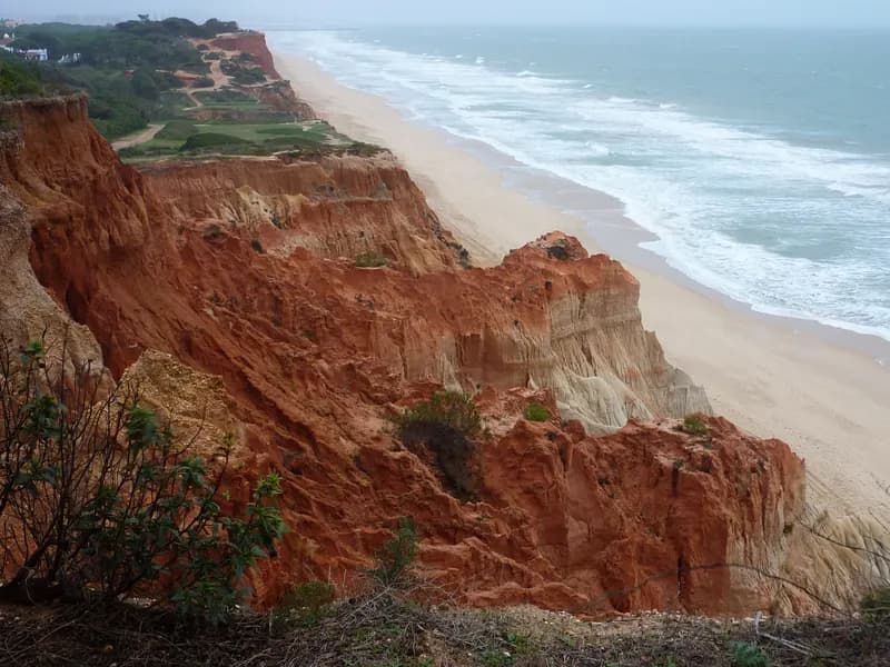 Rode kliffen en het lange zandstrand van Praia da Falésia bij Olhos de Água aan de Algarve