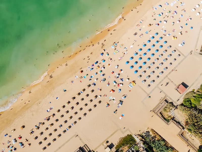 Luchtfoto van het zandstrand Praia do Forte de São João in Albufeira met parasols en de turquoise oceaan