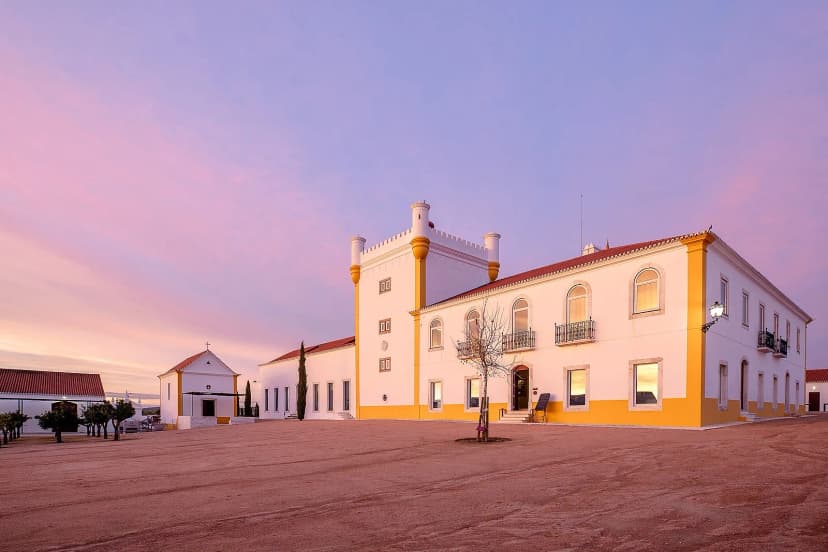 Wijnlandgoed in de Alentejo bij zonsondergang, omringd door wijngaarden en kurkeiken