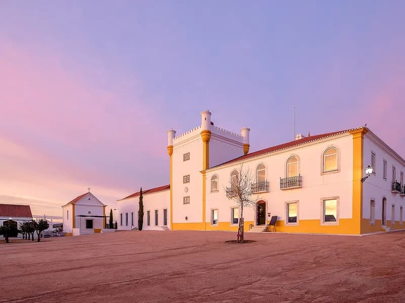 Wijnlandgoed in de Alentejo bij zonsondergang, omringd door wijngaarden en kurkeiken
