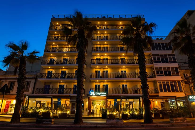 Gevel van Bayview Hotel by ST Hotels aan de promenade van Gżira in de avondschemering