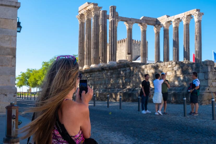 Toeristen fotograferen de Romeinse Tempel van Diana in Évora, Portugal
