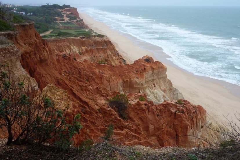 Rode kliffen en het lange zandstrand van Praia da Falésia bij Olhos de Água aan de Algarve