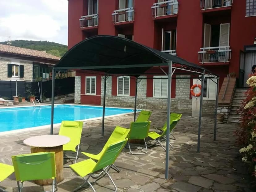 Zwembad en terras met ligstoelen van Hotel Cavalieri in Passignano sul Trasimeno, Umbrië