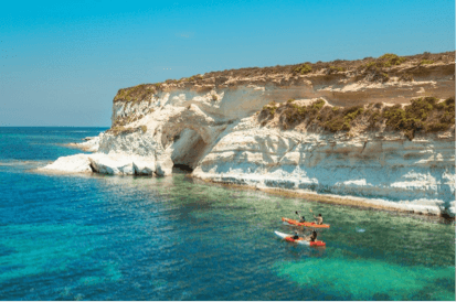 Kajakkers bij een grot in de witte rotskust van Malta