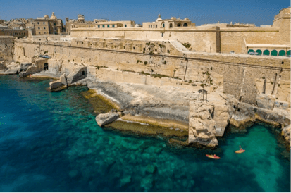 Kajakkers bij de rotsachtige kustlijn van Malta met turquoise water